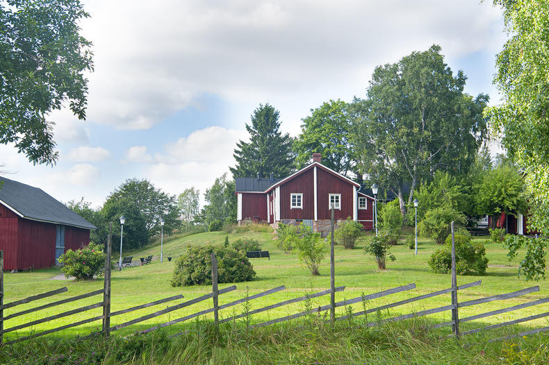 Krookilan kotiseutukeskuksen seiväsaita ja punaisia taloja kesällä.