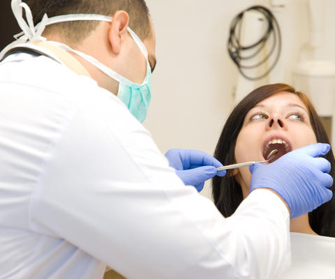 Hammaslääkäri tutkii naisen hampaita.