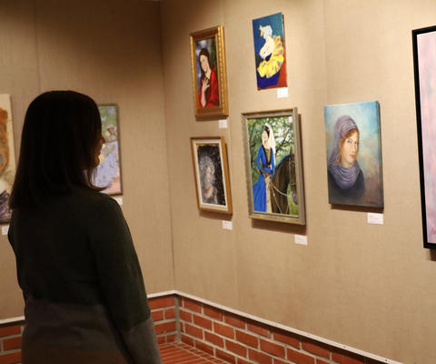 Henkilö katsoo taideteoksia näyttelyssä