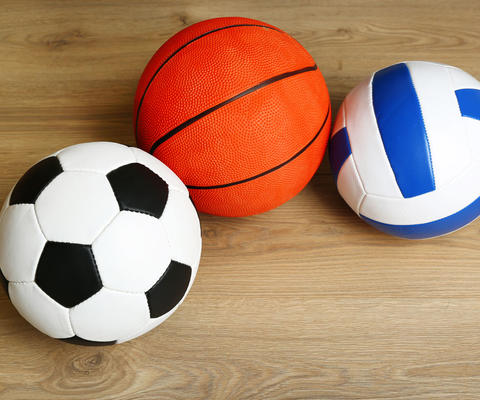 Jalkapallo, koripallo ja lentopallo lattialla.