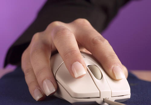 Naisen kädessä tietokoneen hiiri.