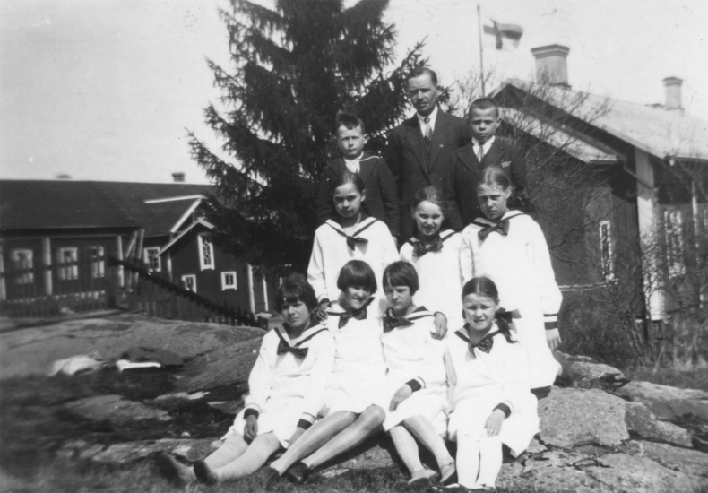 Opettaja Pekka Tuovinen ja Mahittulan koulun jatkoluokkalaiset päättäjäisten jälkeen koulun pihamaalla 1920-luvulla. 