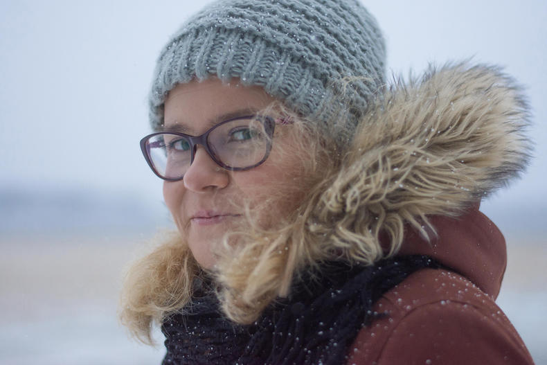 Valokuvaaja Tiuku Pennolan ottamassa kuvassa nainen talvisissa ulkoiluvaatteissaan.