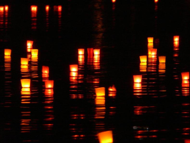 Kynttilöitä vedessä pimeällä.